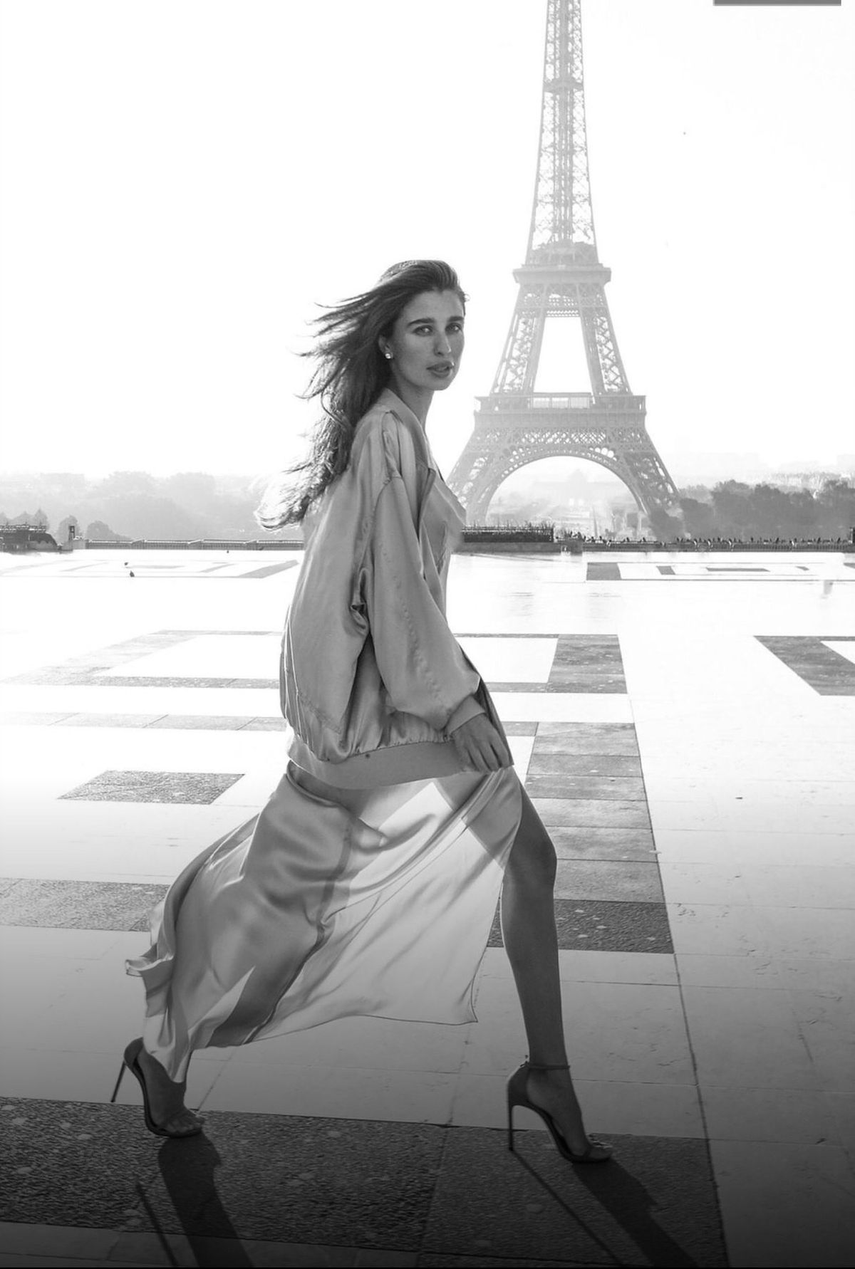A black-and-white fashion portrait in front of the Eiffel Tower